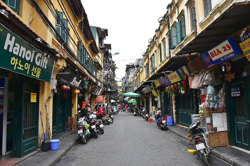 A narrow street in Hanoi's Old Quarter lined with shops and signage